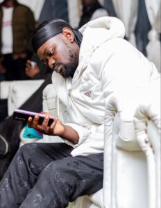 Prince Indah scrolling through his phone