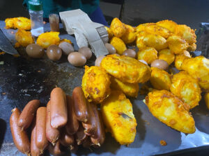 Kenyan street food vendor selling smokies, boiled eggs, and potatoes by the roadside