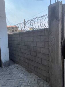 The apartment has a barbed wire on the wall around it